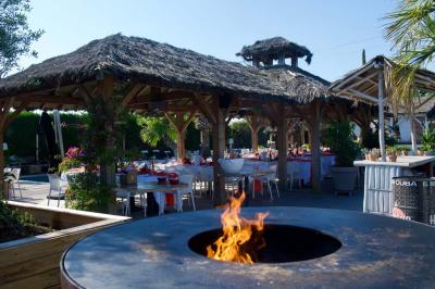 Salle de réception élégante avec tables rondes décorées de fleurs blanches et serviettes pliées, ambiance lumineuse.