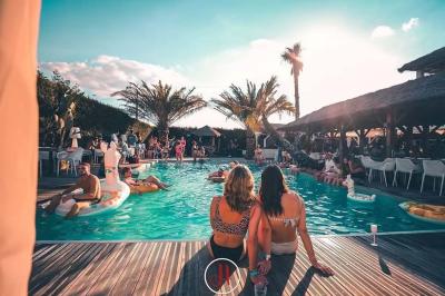 Salle de réception élégante avec tables rondes décorées de fleurs blanches et serviettes pliées, ambiance lumineuse.