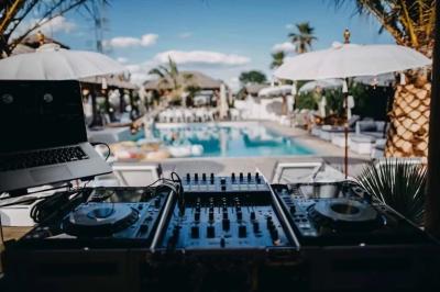 Salle de réception élégante avec tables rondes décorées de fleurs blanches et serviettes pliées, ambiance lumineuse.