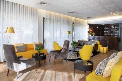 Façade d'un bâtiment moderne en bois clair avec des fenêtres, sous un ciel bleu dégagé.