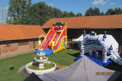 Plusieurs tentes colorées installées sur un terrain herbeux entouré d'arbres.
