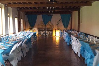 Plusieurs tentes colorées installées sur un terrain herbeux entouré d'arbres.