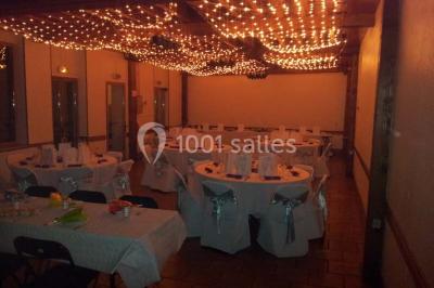 Plusieurs tentes colorées installées sur un terrain herbeux entouré d'arbres.