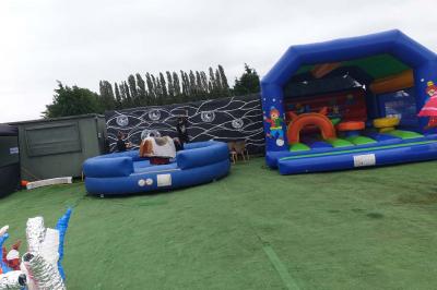 Plusieurs tentes colorées installées sur un terrain herbeux entouré d'arbres.