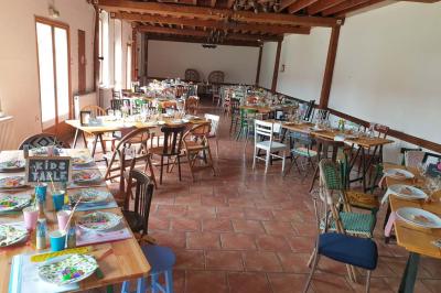 Plusieurs tentes colorées installées sur un terrain herbeux entouré d'arbres.