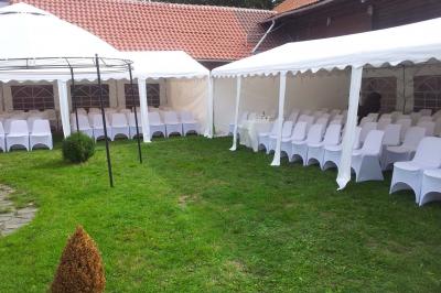 Plusieurs tentes colorées installées sur un terrain herbeux entouré d'arbres.