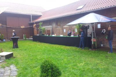 Plusieurs tentes colorées installées sur un terrain herbeux entouré d'arbres.