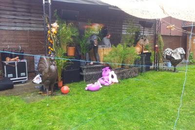 Plusieurs tentes colorées installées sur un terrain herbeux entouré d'arbres.