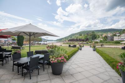 Chambre d'hôtel lumineuse avec lit double, bureau, deux fauteuils, télévision murale et grande fenêtre donnant sur un…