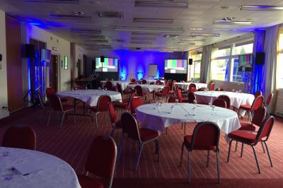 Chambre d'hôtel lumineuse avec lit double, bureau, deux fauteuils, télévision murale et grande fenêtre donnant sur un…