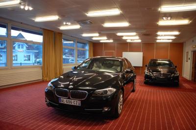 Chambre d'hôtel lumineuse avec lit double, bureau, deux fauteuils, télévision murale et grande fenêtre donnant sur un…