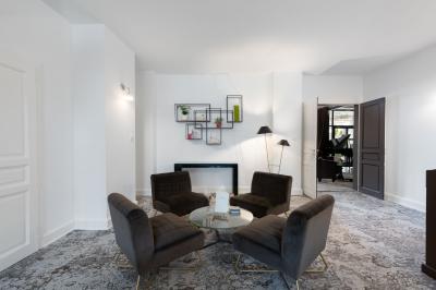 Chambre d'hôtel lumineuse avec lit double, bureau, deux fauteuils, télévision murale et grande fenêtre donnant sur un…