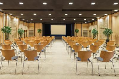 Deux tables de massage dans une salle lumineuse avec étagères en bois, décorée de bougies et d'objets apaisants.