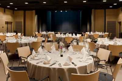 Deux tables de massage dans une salle lumineuse avec étagères en bois, décorée de bougies et d'objets apaisants.