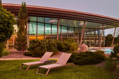 Deux tables de massage dans une salle lumineuse avec étagères en bois, décorée de bougies et d'objets apaisants.
