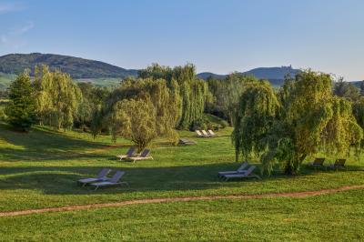 Deux tables de massage dans une salle lumineuse avec étagères en bois, décorée de bougies et d'objets apaisants.