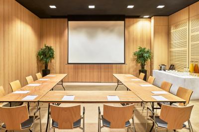 Deux tables de massage dans une salle lumineuse avec étagères en bois, décorée de bougies et d'objets apaisants.