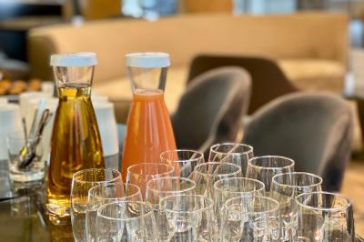 Carafes de jus et d'eau avec des verres vides disposés sur une table dans un espace intérieur lumineux.