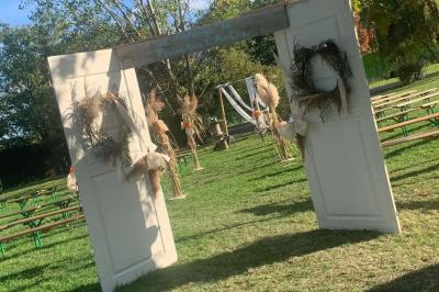 Tables rondes empilées verticalement et chaises empilées dans un couloir étroit avec un sol en carrelage gris.
