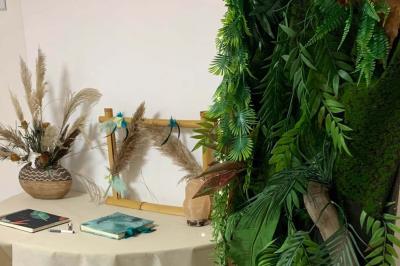 Tables rondes empilées verticalement et chaises empilées dans un couloir étroit avec un sol en carrelage gris.