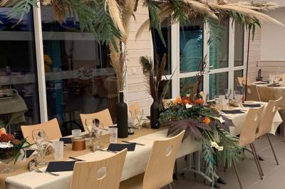 Tables rondes empilées verticalement et chaises empilées dans un couloir étroit avec un sol en carrelage gris.