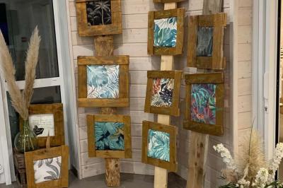 Tables rondes empilées verticalement et chaises empilées dans un couloir étroit avec un sol en carrelage gris.