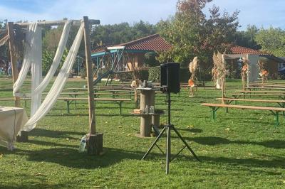 Tables rondes empilées verticalement et chaises empilées dans un couloir étroit avec un sol en carrelage gris.