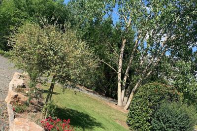 Tables rondes empilées verticalement et chaises empilées dans un couloir étroit avec un sol en carrelage gris.