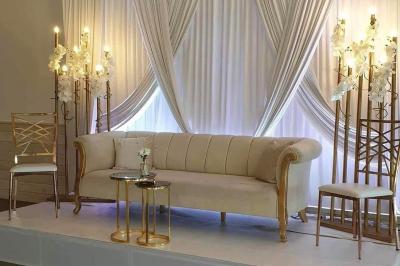 Tables rondes empilées verticalement et chaises empilées dans un couloir étroit avec un sol en carrelage gris.