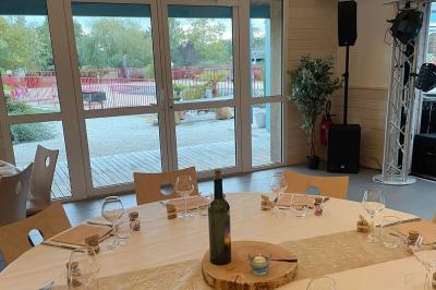 Tables rondes empilées verticalement et chaises empilées dans un couloir étroit avec un sol en carrelage gris.