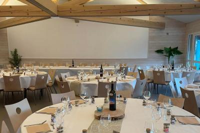 Tables rondes empilées verticalement et chaises empilées dans un couloir étroit avec un sol en carrelage gris.