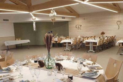 Tables rondes empilées verticalement et chaises empilées dans un couloir étroit avec un sol en carrelage gris.