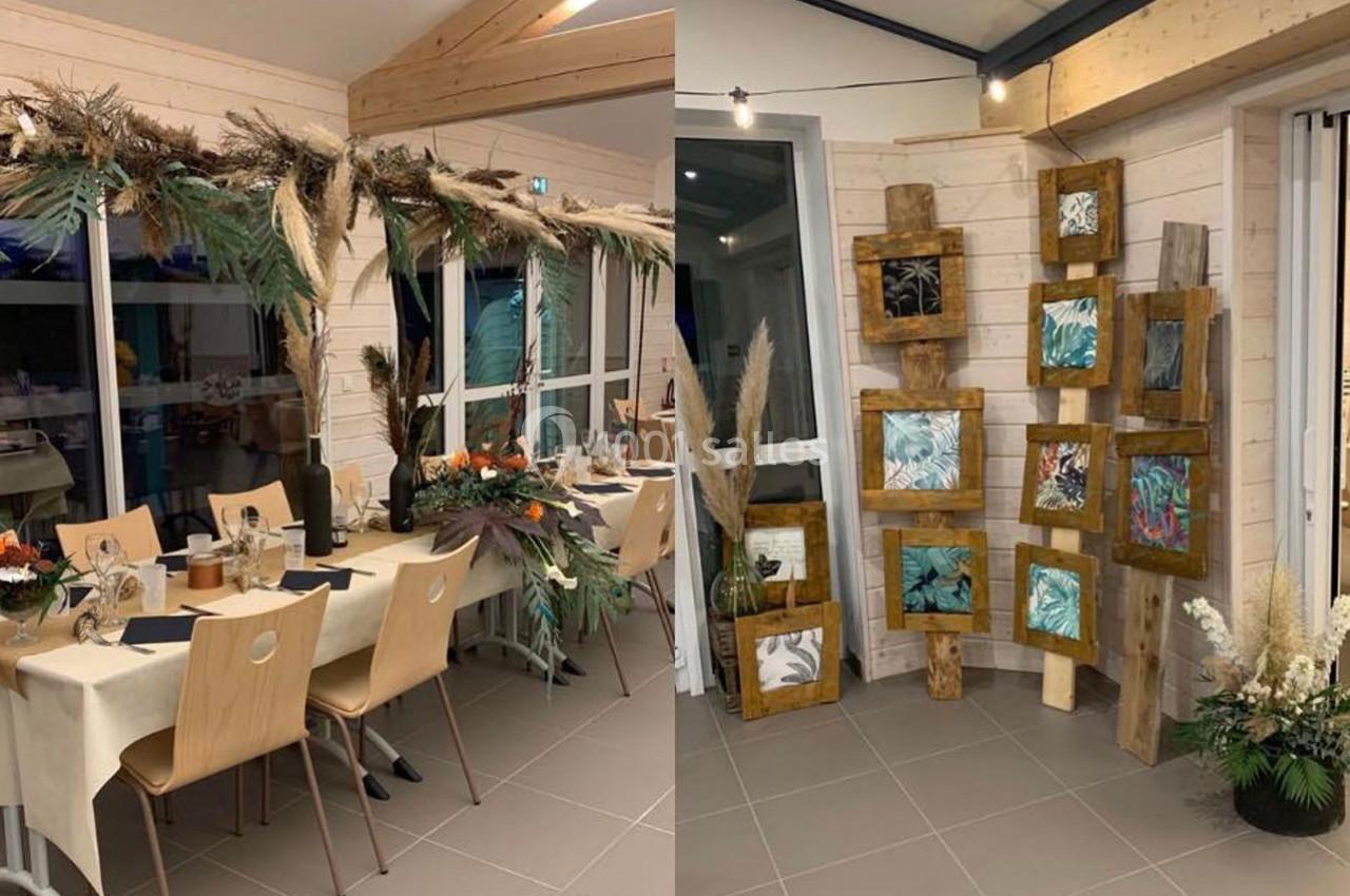 Table décorée avec des éléments naturels et espace d'exposition de cadres en bois avec des illustrations végétales.