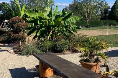 Tables rondes empilées verticalement et chaises empilées dans un couloir étroit avec un sol en carrelage gris.