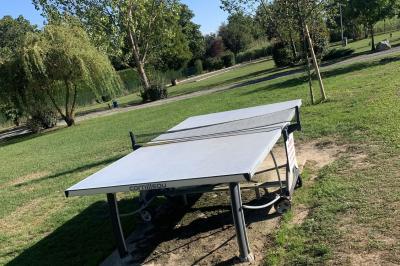 Tables rondes empilées verticalement et chaises empilées dans un couloir étroit avec un sol en carrelage gris.