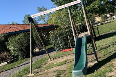 Tables rondes empilées verticalement et chaises empilées dans un couloir étroit avec un sol en carrelage gris.