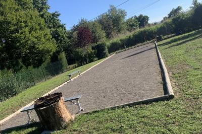Tables rondes empilées verticalement et chaises empilées dans un couloir étroit avec un sol en carrelage gris.