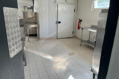 Table dressée avec vaisselle et fleurs bleues près d'une piscine entourée de dalles claires et de végétation.