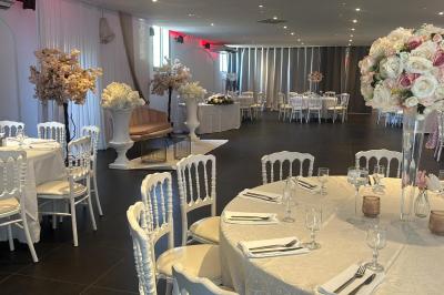 Table dressée avec vaisselle et fleurs bleues près d'une piscine entourée de dalles claires et de végétation.