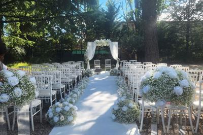 Table dressée avec vaisselle et fleurs bleues près d'une piscine entourée de dalles claires et de végétation.