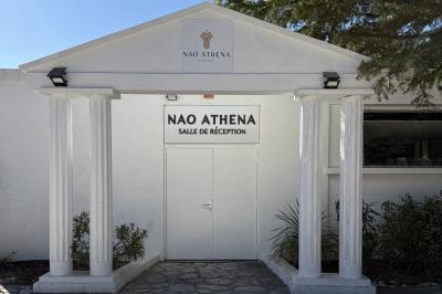 Table dressée avec vaisselle et fleurs bleues près d'une piscine entourée de dalles claires et de végétation.
