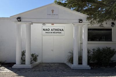 Table dressée avec vaisselle et fleurs bleues près d'une piscine entourée de dalles claires et de végétation.