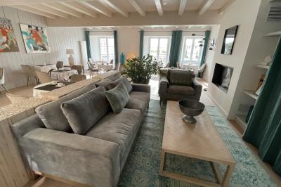 Salle de réunion avec des chaises dorées à assise rouge, une table ronde au premier plan et des tableaux accrochés au mur.