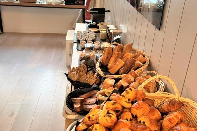Salle de réunion avec des chaises dorées à assise rouge, une table ronde au premier plan et des tableaux accrochés au mur.