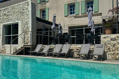 Salle de réunion avec des chaises dorées à assise rouge, une table ronde au premier plan et des tableaux accrochés au mur.
