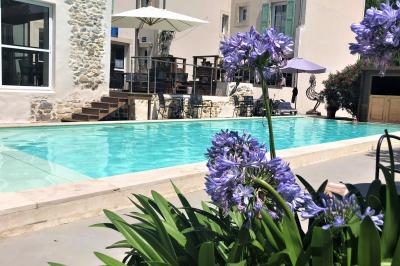 Salle de réunion avec des chaises dorées à assise rouge, une table ronde au premier plan et des tableaux accrochés au mur.