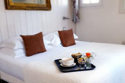 Salle de réunion avec des chaises dorées à assise rouge, une table ronde au premier plan et des tableaux accrochés au mur.