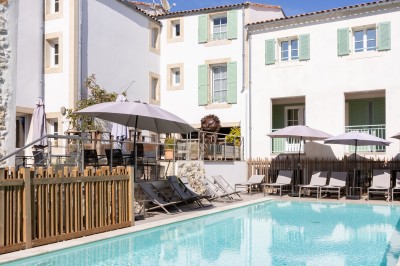 Salle de réunion avec des chaises dorées à assise rouge, une table ronde au premier plan et des tableaux accrochés au mur.