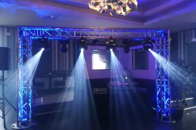 Jeu de lumières colorées projetées depuis une installation de DJ avec une table et des structures lumineuses.