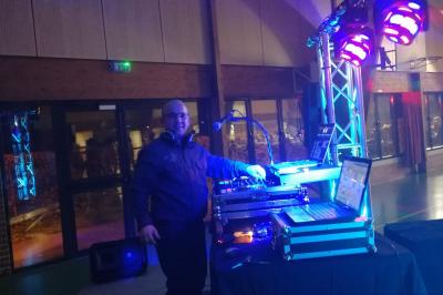 Jeu de lumières colorées projetées depuis une installation de DJ avec une table et des structures lumineuses.